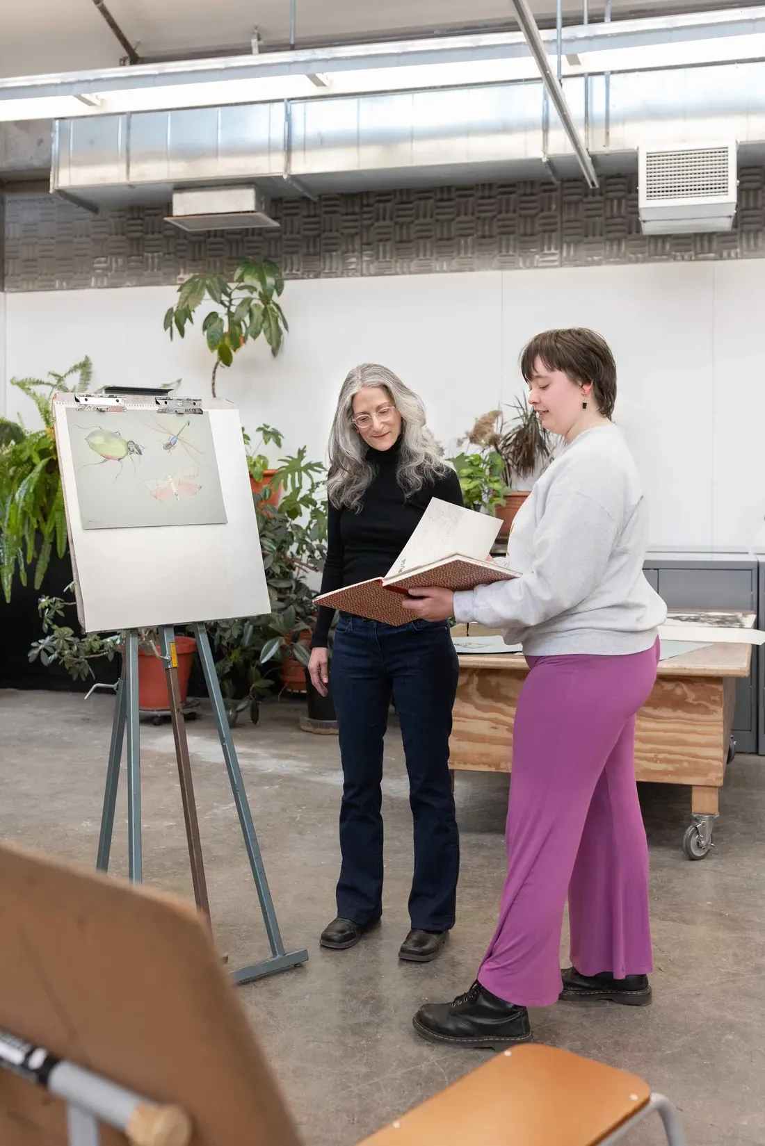 Susan D’Amato showing student a painting.